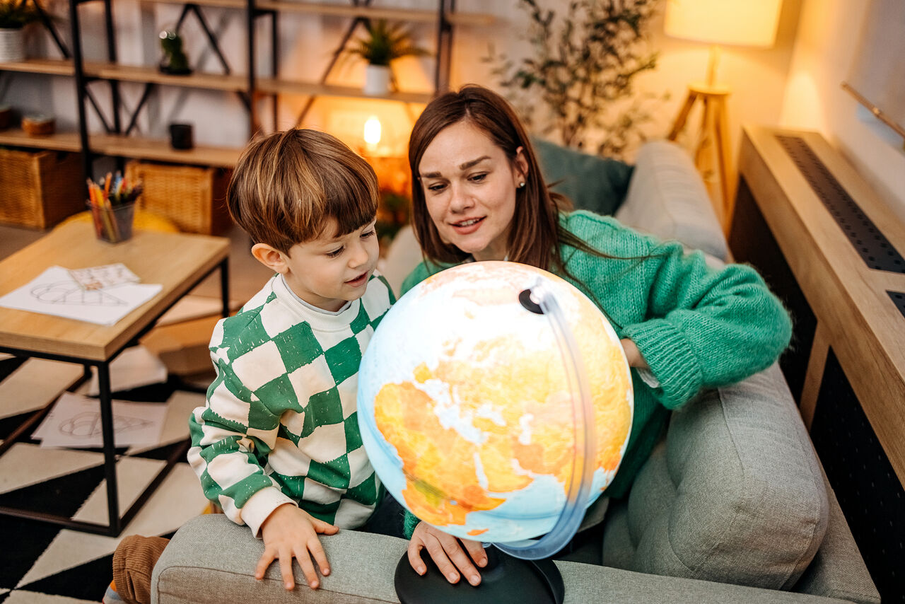 A mother and son playing with a globe